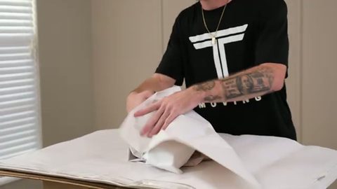 mover wrapping a sculpture in packing paper