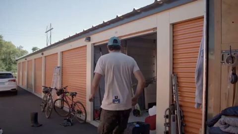 mover walking up to an open storage unit in a facility row